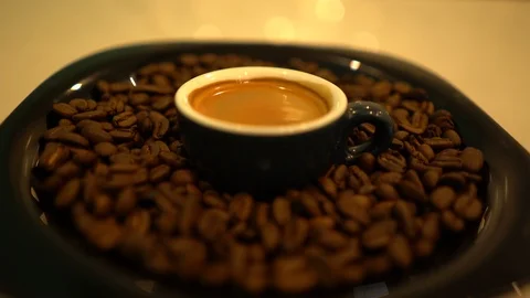 Close-up a cup of coffee with coffee beans in the plate Video stock 125927289