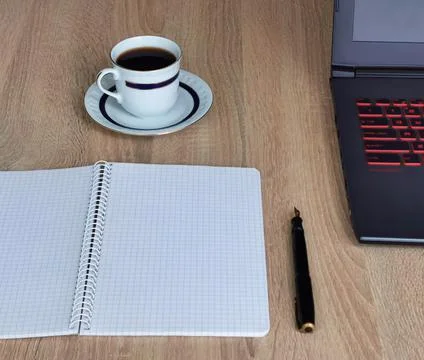 Close up cup of coffee, laptop computer, notebook and pen on wooden table Stock Photos