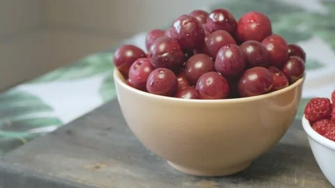 Close up of a cup of fresh cherry and raspberry on cutting board Stock Footage 134069406