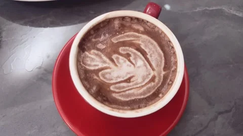 Close-up of a cup of latte coffee, topped with a heart-shaped foam. latte art Stock Footage 309373140
