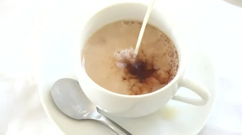 Close up of a cup of tea being poured and adding milk using studio lighting Stock Footage 65860398