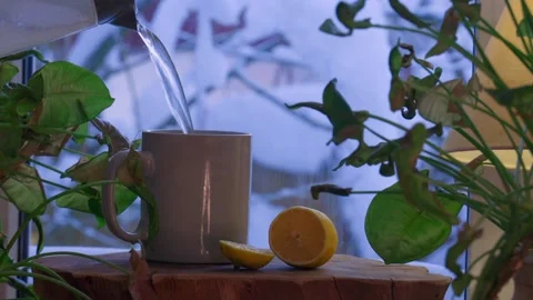 Close-up of a cup of tea as hot water is being poured in a cozy winter interior. Video stock 328117983