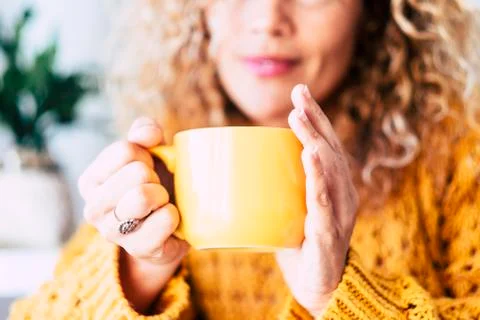 Close up on cup with tea or coffe drink inside and beautiful defocused woman  Stock Photos
