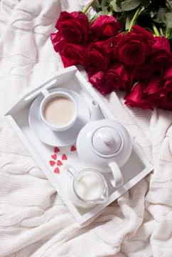 Close up of cup of tea with red rose on the white tray Stock Photos