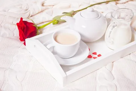 Close up of cup of tea with red rose on the white tray 库存照片