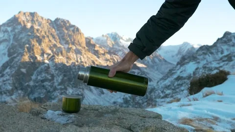 Close-up of a cup into which a hot drink is poured from a thermos Stock Footage 143724838