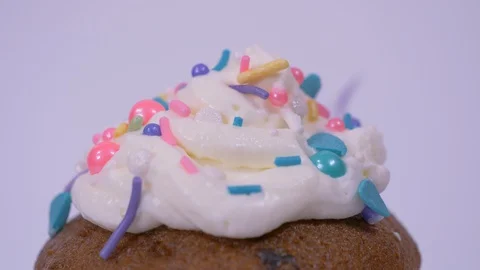 Close up of Cupcake Spinning with Sprinkles Falling on Top. Cupcake Video stock 128155568