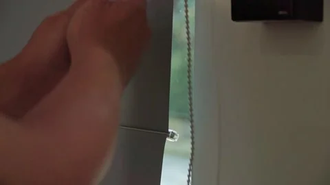 Close-up of a curtain chain being pulled to open a window covering. Stock Footage 338191273