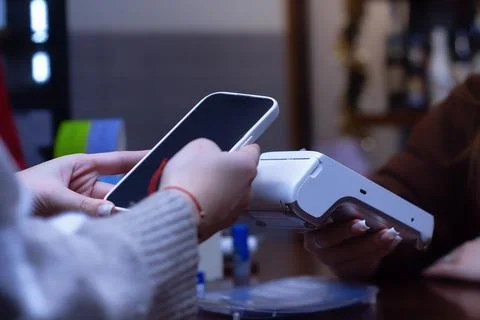 Close-up of a customer making a contactless payment with a smartphone at a po Stock Photos