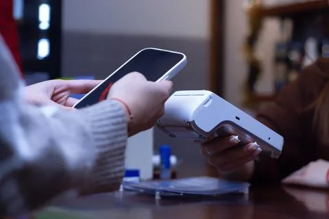 Close-up of a customer making a contactless payment with a smartphone at a po Stock Photos