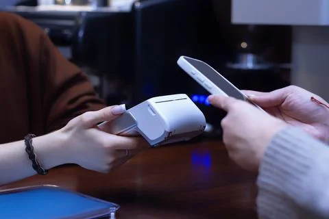 Close-up of a customer making a contactless payment with a smartphone at a po Foto stock