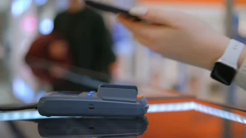 Close up customer paying with an NFC contactless smartphone with a card machine. Stock Footage 231545430