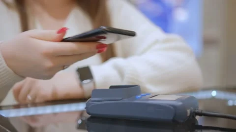 Close up customer paying with an NFC contactless smartphone with a card machine. Видео 231741653