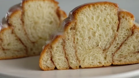 Close-up cut of cinnamon rolls on a plate. Sweet cream cheese frosting pouring Stock Footage 146501677