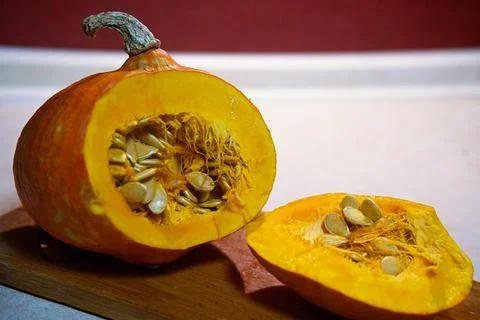 Close-up of a cut orange pumpkin on a kitchen table Stock Photos
