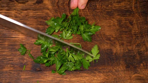 Close-up of cut parsley on a board in the kitchen with a knife. Stock Footage 249959765