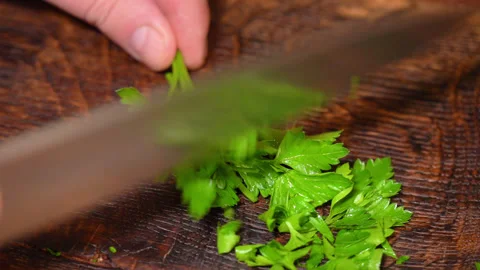 Close-up of cut parsley on a board in the kitchen with a knife. Stock Footage 254272403