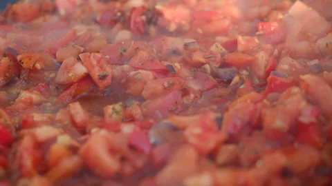 Close up of cut tomatoes with red peppers and spices languishing in pan Stock Footage 301364657