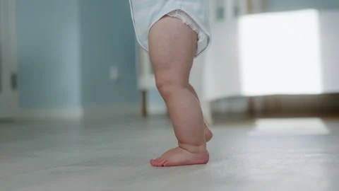 Close-up of a cute baby getting up on his feet. First steps Stock Footage 303040269