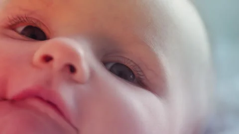 Close-up of cute baby looking around with wonder, early sensory development Stock Footage 325306366