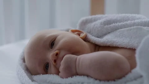 Close up, cute baby lying on bed in towel, after bath Stock Footage 306009999
