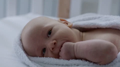 Close up, cute baby lying in bed on towel, after bath. Maternity Stock Footage 306010282