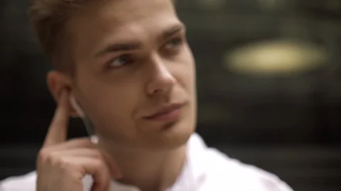 Close-up of a cute blond guy is listening to his favorite online radio Stock Footage 114454291