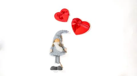 Close up of cute doll with gift boxes in form of heart on isolated white back Stock Photos