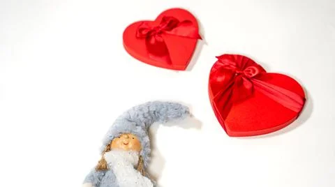 Close up of cute doll with gift boxes in form of heart on isolated white back Stock Photos
