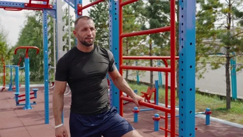 Close up of cute healthy young guy leaning on metal gym and looking for leisure 스톡 동영상 135362742