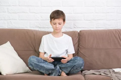 Close up cute little boy using smartphone, looking at screen, child holding Foto stock
