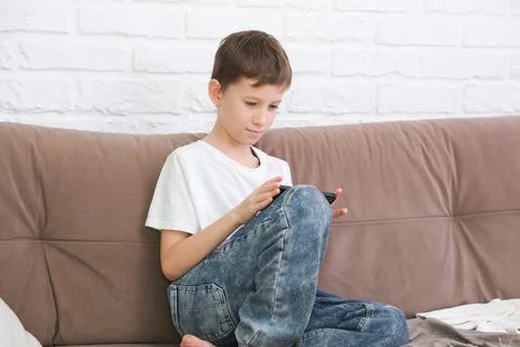 Close up cute little boy using smartphone, looking at screen, child holding Foto stock