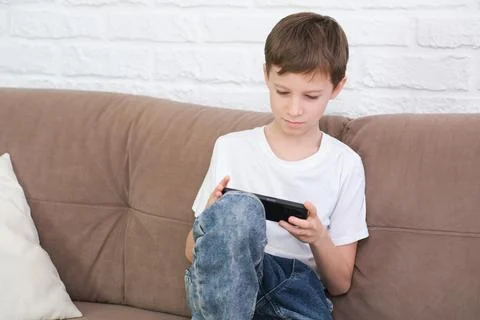 Close up cute little boy using smartphone, looking at screen, child holding Stock Photos