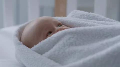 Close up, cute newborn baby lying in bed wrapped in towel after bath Stock Footage 306006076