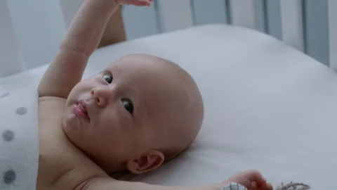 Close-up, cute newborn baby lying in bed, stretching his arms Stock Footage 306044582