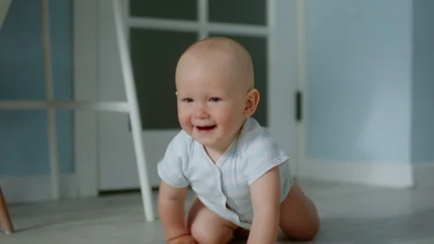 Close-up, cute smiling babbie runs on all fours towards the camera Stock Footage 302978842