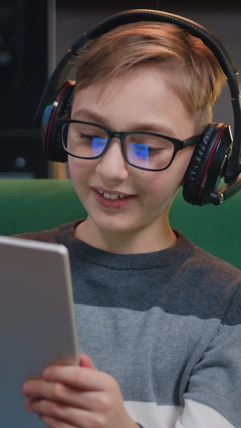 Close up of cute smiling smart boy using digital tablet browsing, streaming and  Stock Footage 334935101