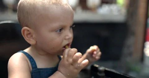 Close-up of cute toddler eating fries with blurry background Stock Footage