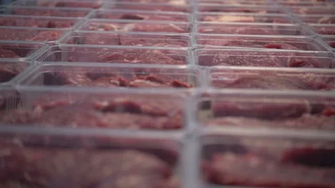 Close up cuts of fresh raw beef meat in trays on table in slaughterhouse. Slow Stock Footage 156057588