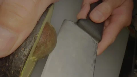 Close up cutting avocado and removing seed Stock Footage 336658127