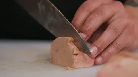 Close up cutting foie gras with a knife raw lunch condiment preparation Stock Footage 103287930