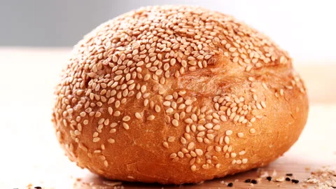 Close up cutting fresh hamburger bun, bread rolls with sesame seeds Stock Footage 165347672