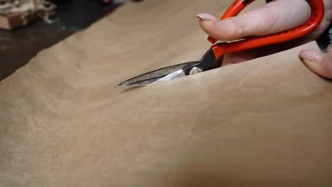 Close-Up Cutting Kraft Paper with Scissors Stock Footage 315528519