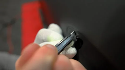 Close up of a cutting matte vinyl wrap on a car body panel in a workshop. Stock Footage 334056375