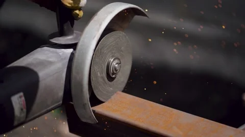 Close-up of a cutting a metal beam. Male worker with angular grinding machine is Stock Footage 144339953