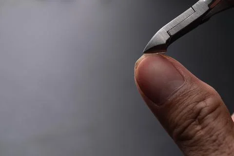 Close-up of cutting nails. Hands are cutting nails using nail clippers. Stock Photos