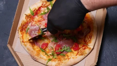 Close-up cutting pizza with a round cutter knife slow motion. camera movement Stock Footage 169186150