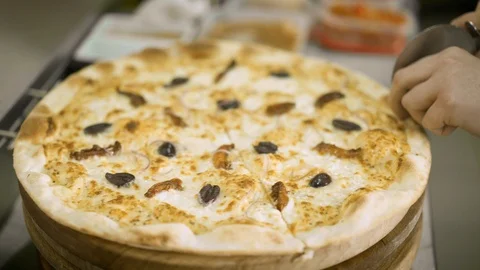 Close up cutting pizza on slices with roller knife in pizzeria. 스톡 동영상 121853216