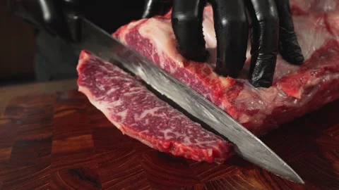 Close Up of Cutting Raw Meat Chunk on Wooden Cutting Board 動画素材 335257011