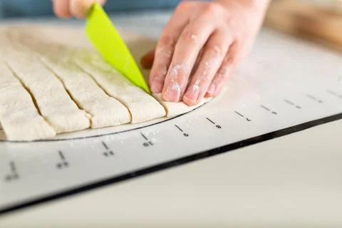 Close-up of cutting the rolled dough into equal parts according to the markup Stock Photos